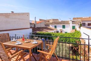 a wooden table and chairs on a balcony with a view at Apartamentos Turísticos Olivares in Mota del Cuervo