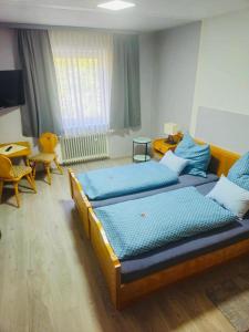 a bedroom with two beds and a desk and a table at Bellas Mühlbachtal in Friedenfels