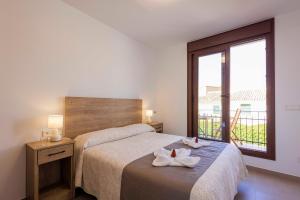 a bedroom with two beds and a large window at Apartamentos Turísticos Olivares in Mota del Cuervo
