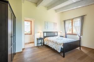 a bedroom with a bed and two tables in it at Chalet Rosmarino in Trequanda