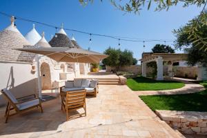 a patio with a table and chairs and an umbrella at Dimora Dormio in Monopoli
