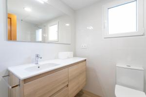 a white bathroom with a sink and a mirror at Bungalow 213 in Alicante +22 photos