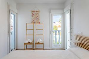 a white bedroom with a bed and a large window at Bungalow 213 in Alicante