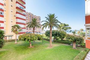 a park with palm trees in front of a building at Apartamento Sol Playa Torrox A55 in Torrox Costa