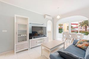 a living room with a couch and a tv at Apartamento Sol Playa Torrox A55 in Torrox Costa