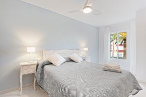 a white bedroom with a bed and a ceiling fan at Apartamento Sol Playa Torrox A55 in Torrox Costa +20 photos