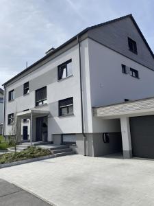 a white building with a garage at Ferienwohnung Sämann in Oberkirch