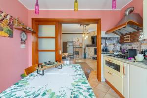 a kitchen with pink walls and a table and a kitchen with a stove at La Casa Del Vagabondo in Belvedere +35 photos