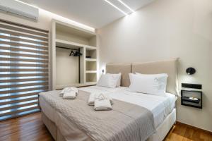 a bedroom with a large bed with two towels on it at The Apex Boutique Apartment B2 in Athens