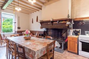 a kitchen with a table and a large fireplace at La Serre in Laborde +15 photos