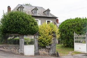 an old house with a white gate and trees at La Serre in Laborde