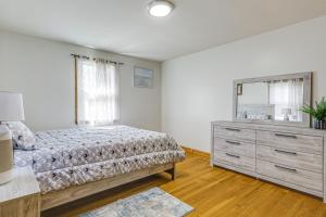 a bedroom with a bed and a dresser and a mirror at Walk to Shops & Eats! Attleboro Basecamp in Attleboro
