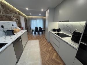 a kitchen with white counter tops and a dining room at Santa Baia in Veiga