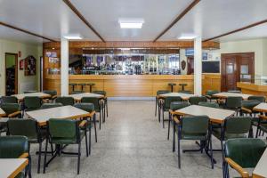 a dining room with tables and chairs and a bar at Bungalow A4 in Pontevedra