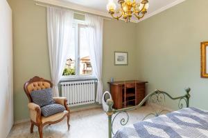 a bedroom with a bed and a chair and a window at Villa La Lanterna Bianca a Bagnone in Bagnone +26 photos
