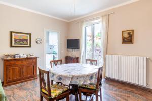 a dining room with a table and chairs and a television at Villa La Lanterna Bianca a Bagnone in Bagnone