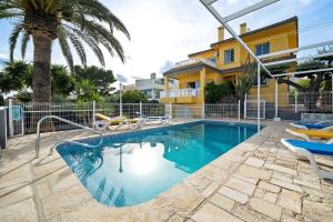a swimming pool with chairs and a house at Villa Amador in L'Ampolla