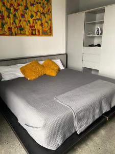 a bed with two yellow pillows on top of it at Modern loft with panoramic views in Monterrey