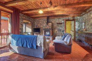 a living room with two chairs and a fireplace at El Mirador de Babia in Ríolago