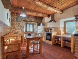 a kitchen with a wooden table and a stone wall at El Mirador de Babia in Ríolago