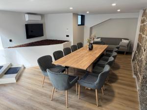 a dining room with a wooden table and chairs at Santa Baia in Veiga +60 photos