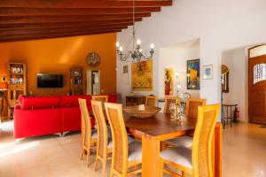 ein Esszimmer mit einem Tisch und einem roten Sofa in der Unterkunft Finca Soliva in Capdepera