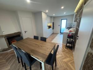 a kitchen and dining room with a wooden table and chairs at Santa Baia in Veiga