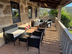 a patio with chairs and tables on a building at Santa Baia in Veiga
