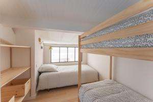 a bedroom with two bunk beds and a window at Villa Rénovée, 5min Plage in Seignosse