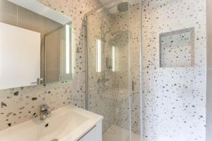 a bathroom with a shower with a sink and a mirror at Villa Rénovée, 5min Plage in Seignosse