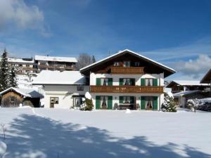 a house with snow on the ground in front at Alpenblick Tilly - Fewo Barmsee 2 in Krün
