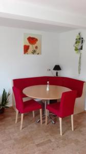 a dining room with a table and red chairs at Fewo Edith in Gersfeld