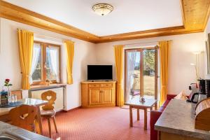a living room with a television and a table at Alpenblick Tilly - Fewo Barmsee 2 in Krün