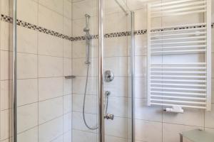 a bathroom with a shower with a glass door at Alpenblick Tilly - Fewo Barmsee 2 in Krün +11 photos
