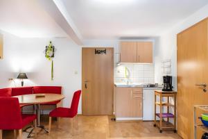a kitchen and a table with red chairs and a room at Fewo Edith in Gersfeld