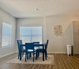 a dining room with a blue table and chairs at The HoneyBee at Coventry Rows in Omaha