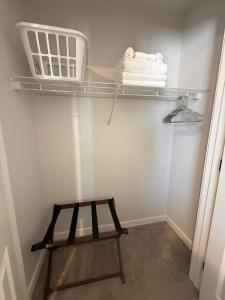 a small closet with a shelf and a stool at The HoneyBee at Coventry Rows in Omaha +14 photos