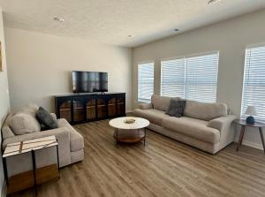 a living room with a couch and a tv at The HoneyBee at Coventry Rows in Omaha