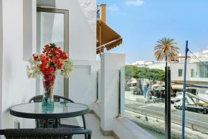 a table with a vase of flowers on a balcony at Albamar 1a in Puerto de Mogán