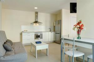 a kitchen and living room with a table and a couch at Albamar 1a in Puerto de Mogán +11 photos