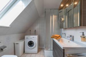 a bathroom with a washing machine and a sink at Haus Deichbrise in Niebüll