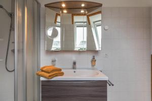 a bathroom with a sink and a mirror and towels at Haus Deichbrise in Niebüll +34 photos