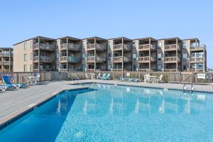 a swimming pool in front of a apartment building at Delightful Diversion in Duck