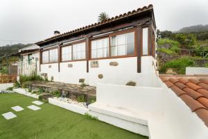 a white house with a green lawn in front of it at Casa Cruz De Tierno in Agulo