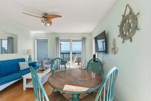 a dining room with a table and chairs and a blue couch at Delightful Diversion in Duck