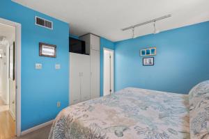 a bedroom with blue walls and a bed at Delightful Diversion in Duck +15 photos