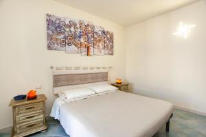 a bedroom with a bed and two paintings on the wall at Casa Francesco in Orosei
