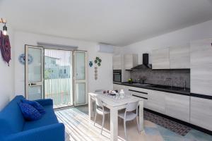 a kitchen with a white table and a blue couch at Casa Francesco in Orosei