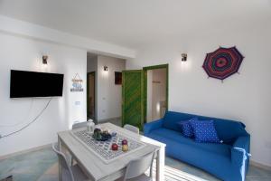 a living room with a blue couch and a table at Casa Francesco in Orosei