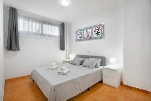 a white bedroom with a white bed and a window at Ocean Park 311 in Adeje +15 photos